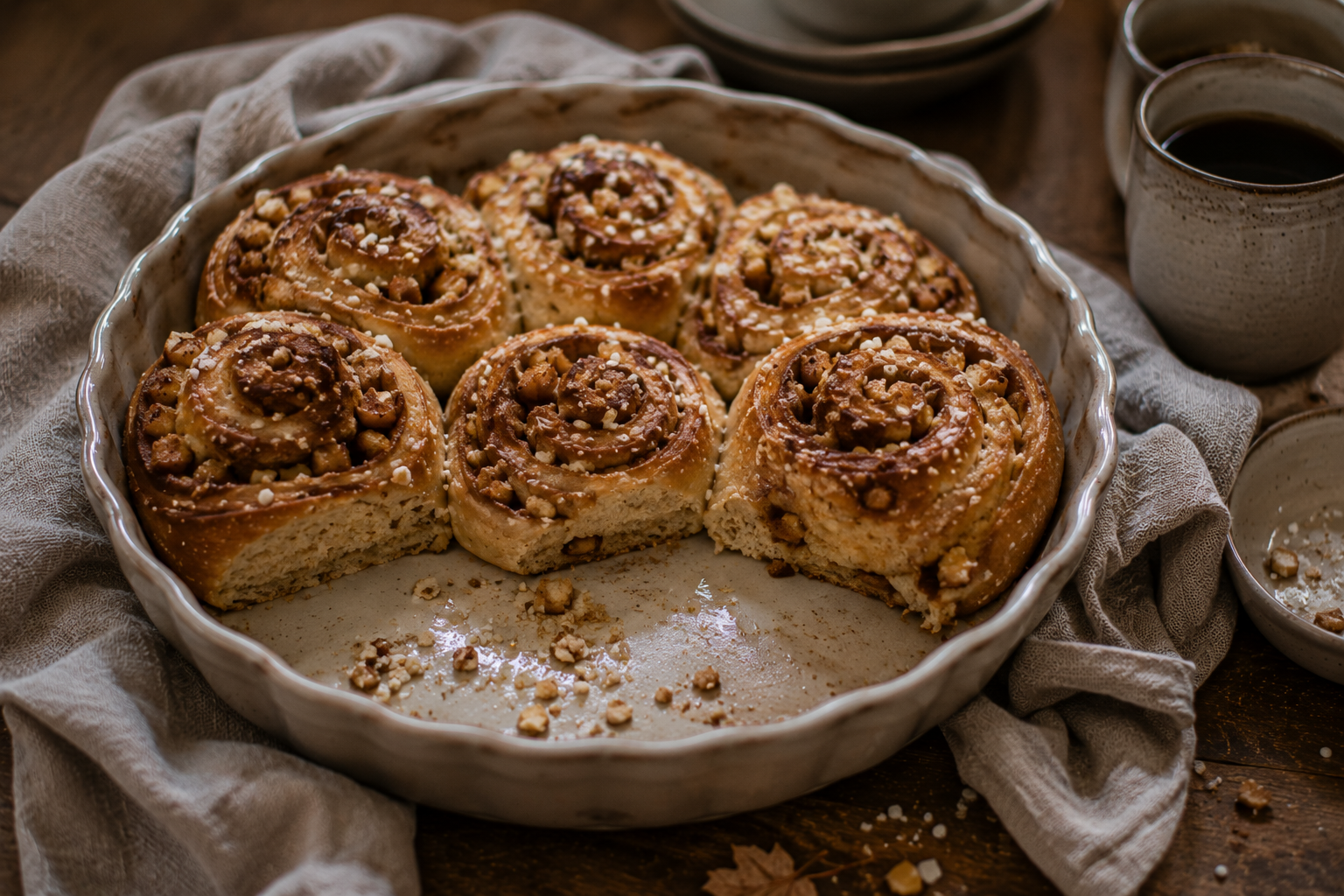 Kleine Apfel-Zimtschnecken in einer Backform auf einem herbstlichen Brunchtisch